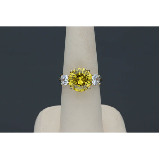Yellow gold citrine ring with diamond-like zircon side stones - elegant three stone design in a ring display with dark gray blackground