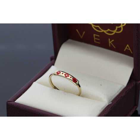 A 10K gold band ring with 3 red clover engraved in its center, presented in a VEKA branded box.
