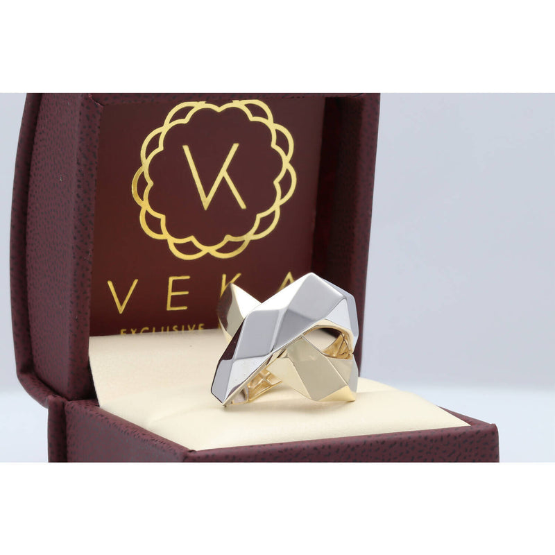 Side angle of a handcrafted interlocking X-link ring in 14k solid gold showing the faceted white and yellow gold surfaces