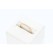 Angled profile view of a dainty 10K yellow gold diamond heart-shaped stackable wedding band by Veka Jewelry